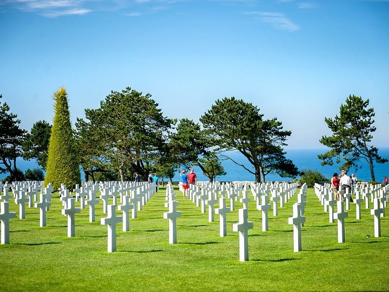 Rows of white crosses at the Normandy American Cemetery with the Channel behind