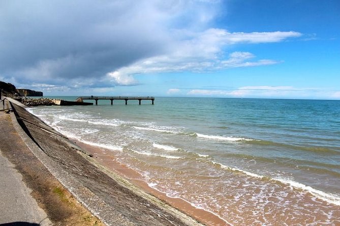 Surf running up a Normandy landing beach beside the sea wall