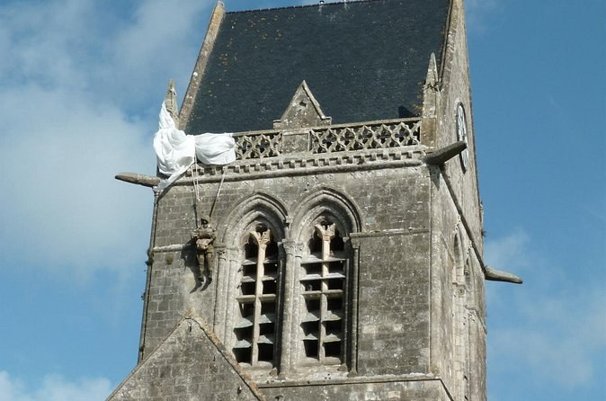The parachute and figure hanging from the church tower at Sainte-Mere-Eglise